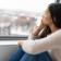A depressed woman looking out the window